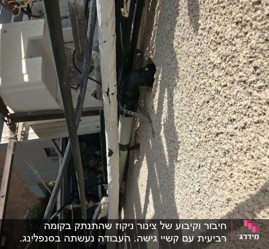 התקנת צינור אינסטלציה וניקוז שחור על קיר חיצוני של בניין בגובה